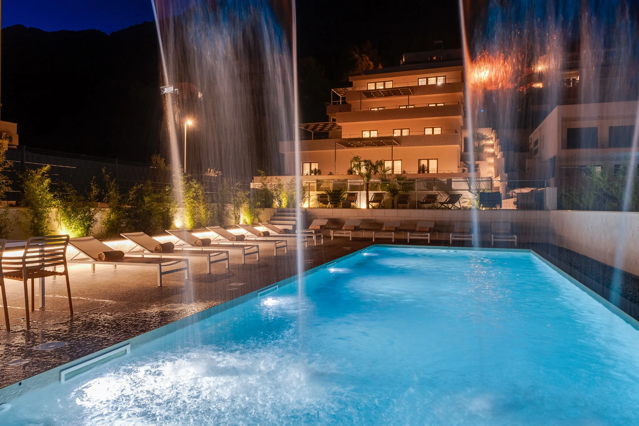 Night pool with waterfall and lighting